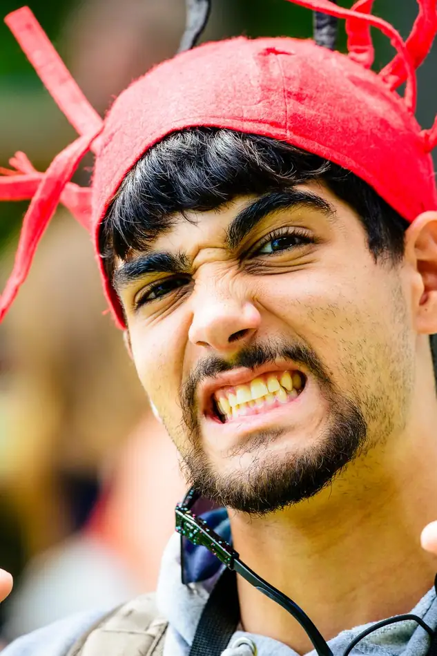 A camper in a red lobster hat, teeth bared in a mock snarl.